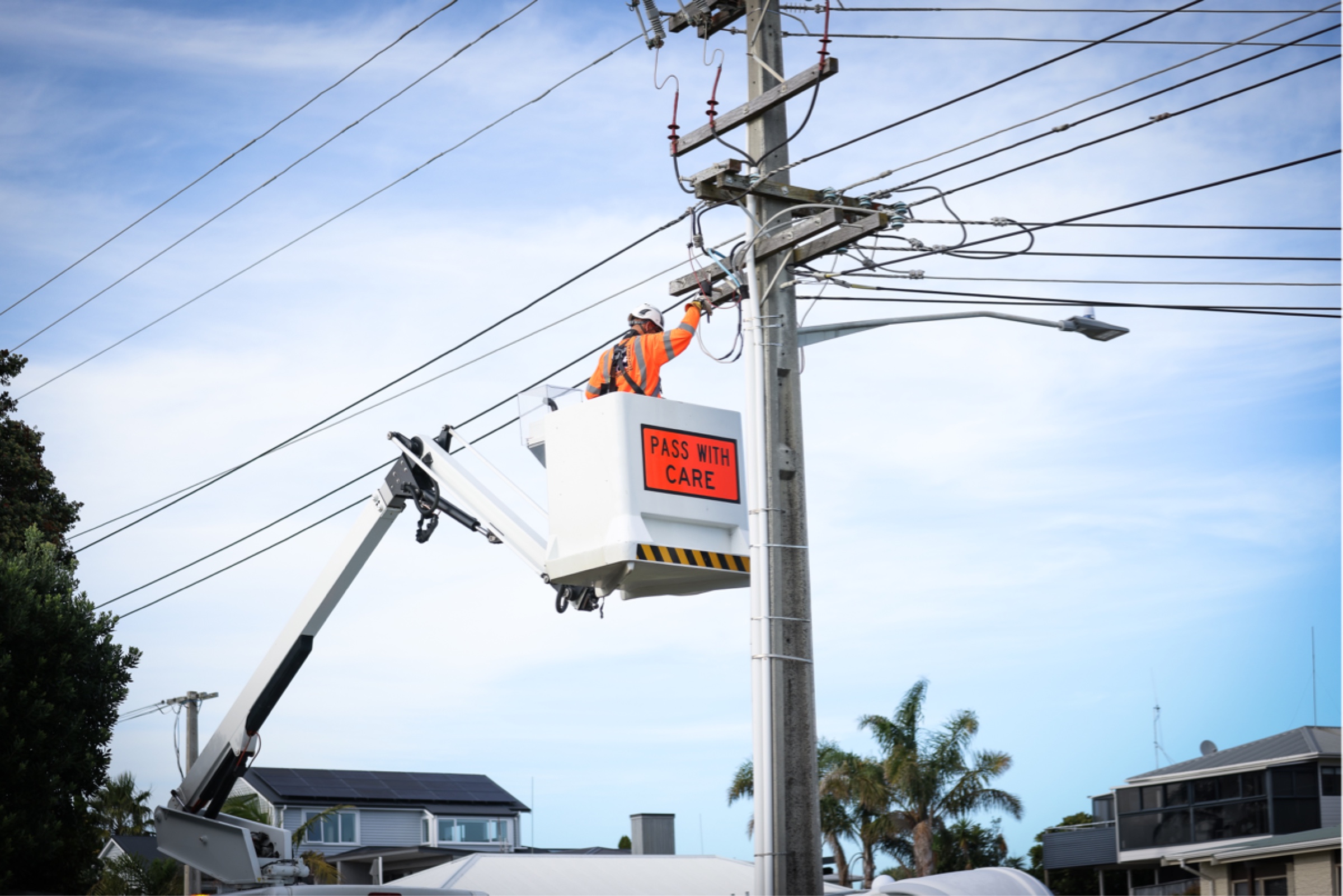Electrian adjusting wiring on a pole.