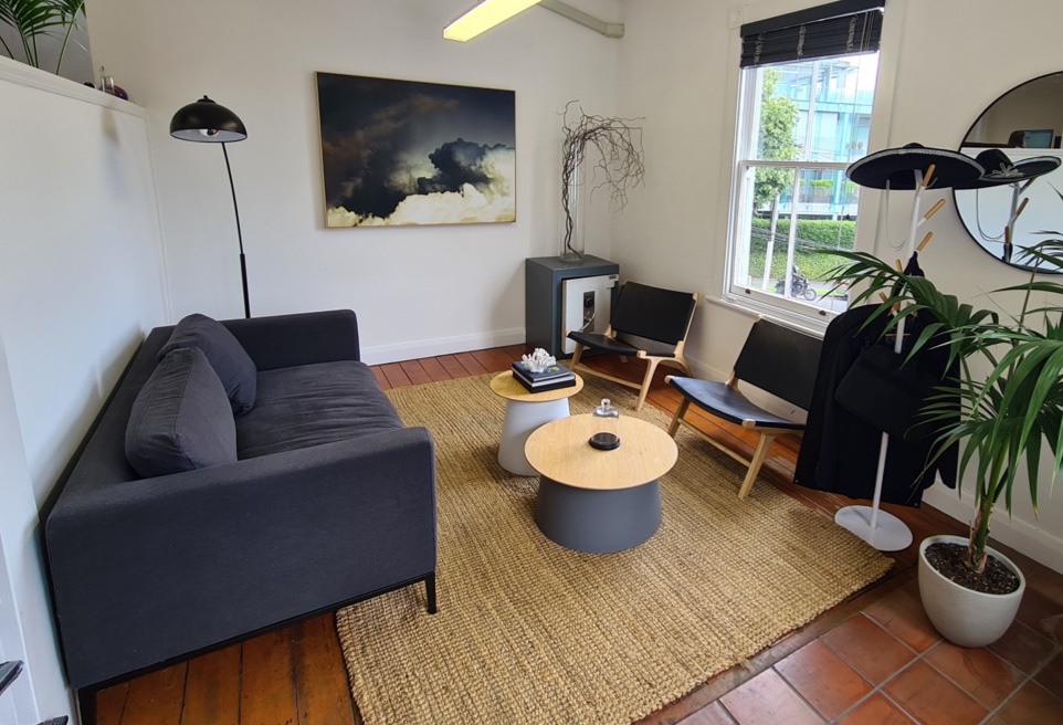 A chill out area in an office, with a sofa and a screen.
