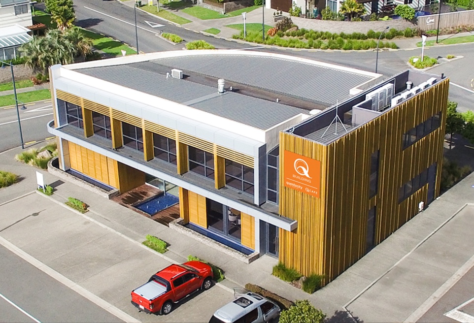 An aerial view of an office block, with cars parked out the front.